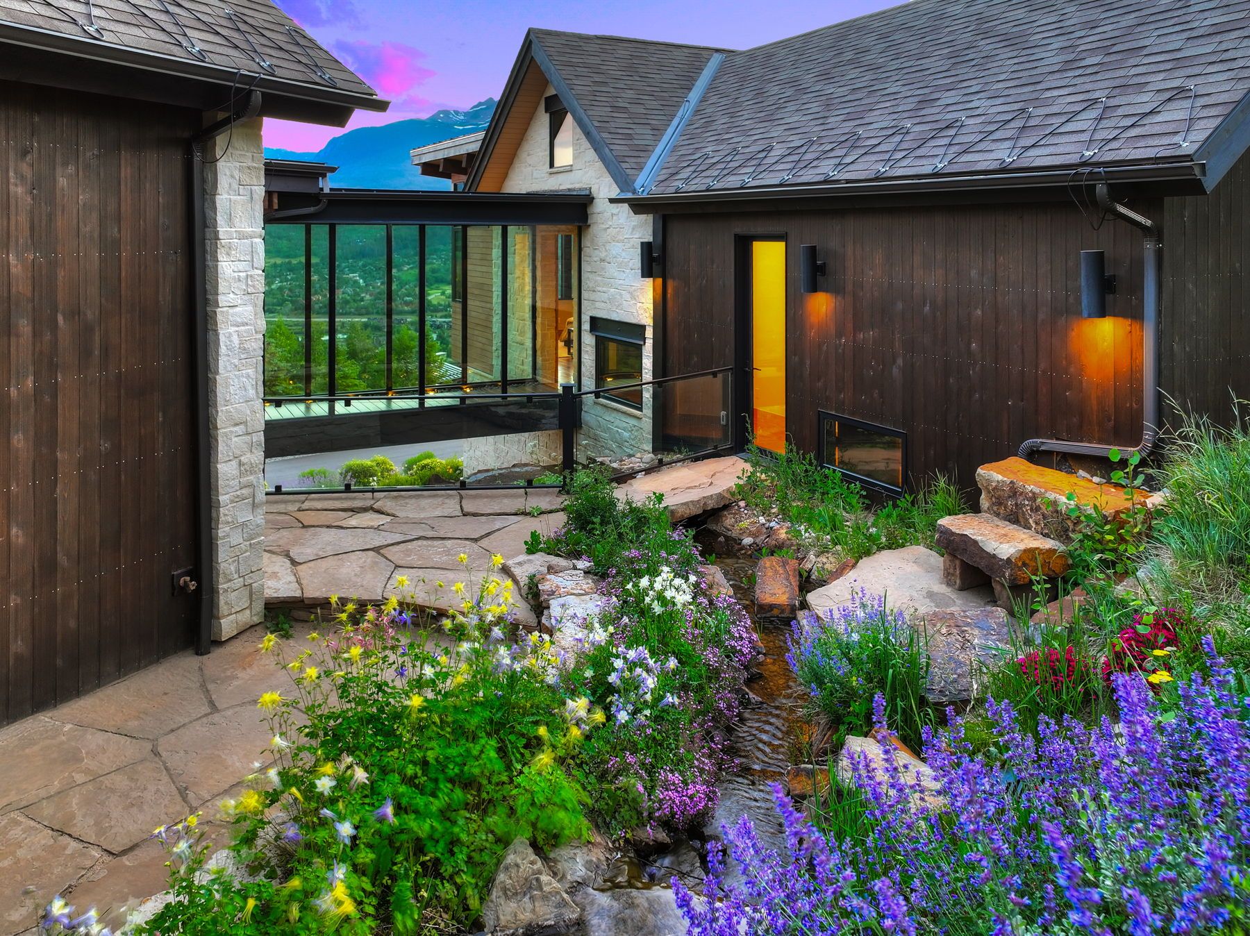 The clear glass passage way brings the outdoors inside.