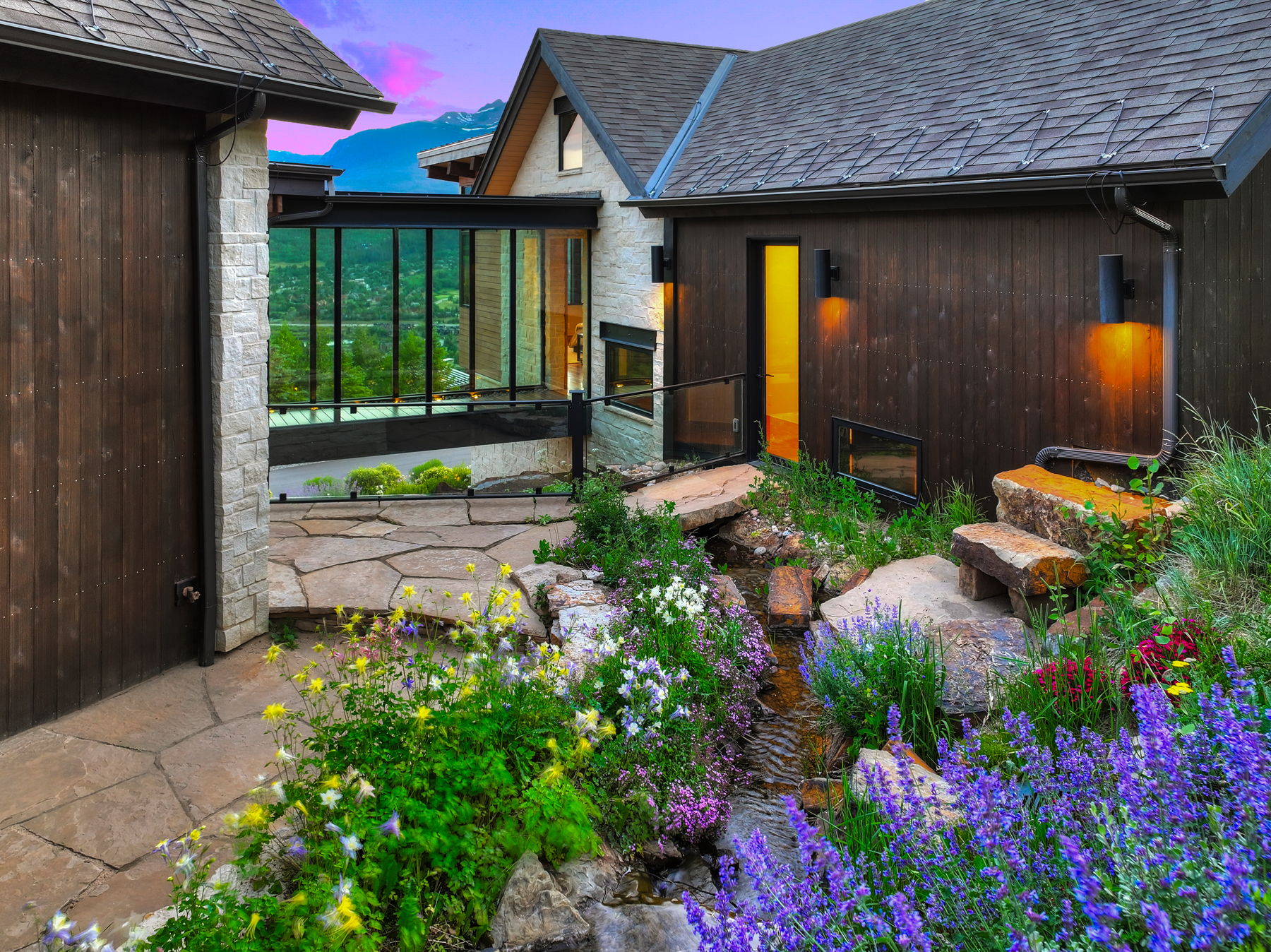 The clear glass passage way brings the outdoors inside.